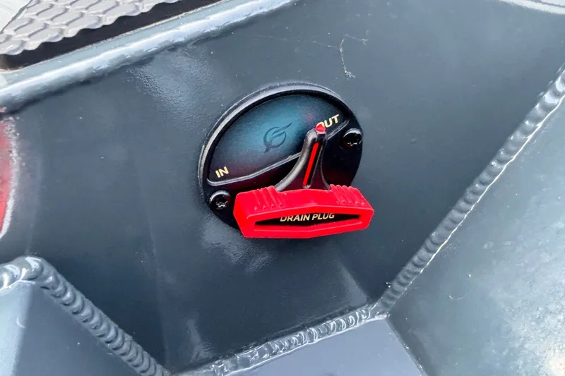 Slide: The Image of Red drain plug on 2025 Ranger RT198P boat, labeled "IN" and "OUT." - 12