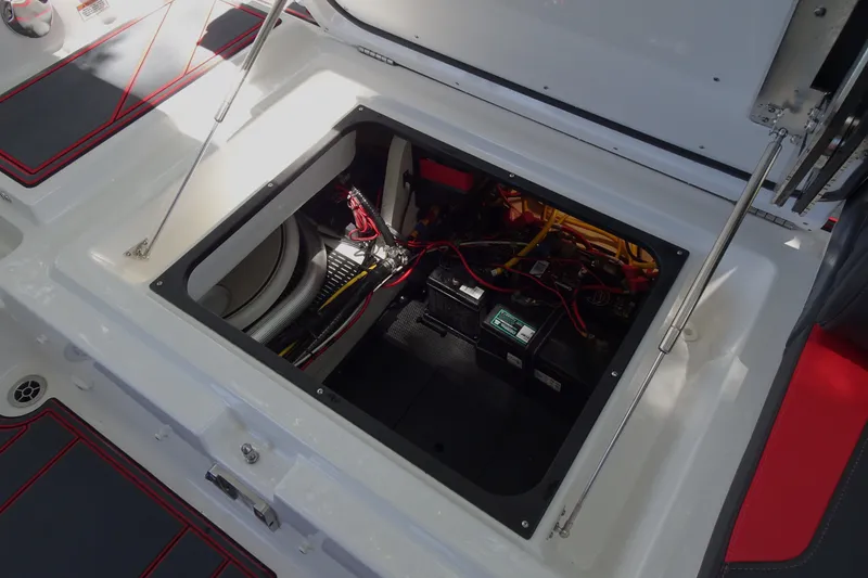 Slide: The Image of Open engine compartment of 2025 Monterey Elite 27 OB boat, showcasing wiring and battery setup. - 28