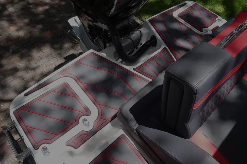 Slide: The Image of 2025 Monterey Elite 27 OB boat interior with red and black seating and deck design. - 15