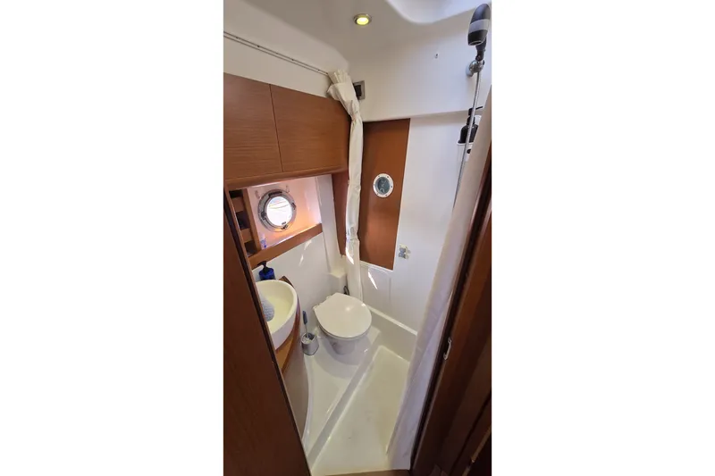 Slide: The Image of Bathroom interior of 2013 Beneteau Gran Turismo 38 yacht, featuring modern fixtures and porthole. - 32