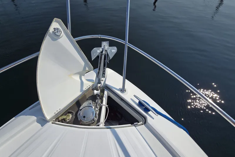 Slide: The Image of Bow of 2013 Beneteau Gran Turismo 38 with anchor compartment open, reflecting sunlight on water. - 38