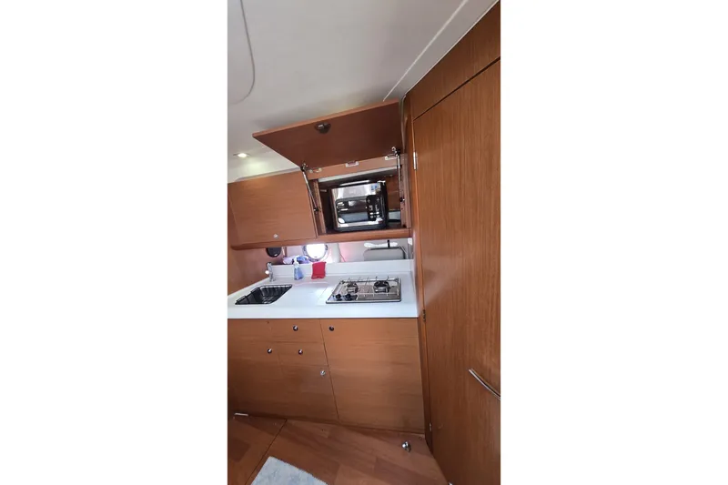 Slide: The Image of 2013 Beneteau Gran Turismo 38 yacht kitchen with wooden cabinetry and modern appliances. - 25