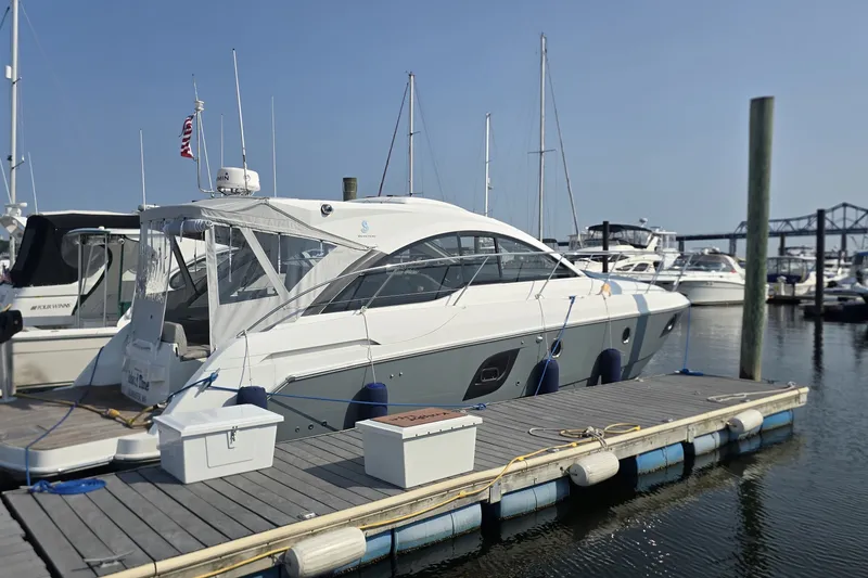 The Image of 2013 Beneteau Gran Turismo 38 yacht docked at marina with other boats. - 0