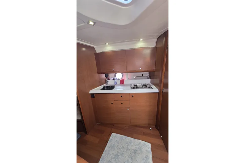 Slide: The Image of 2013 Beneteau Gran Turismo 38 yacht interior kitchen with wooden cabinets and modern appliances. - 23