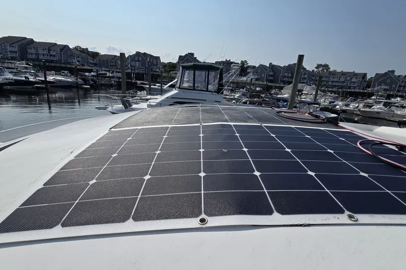 Slide: The Image of 2013 Beneteau Gran Turismo 38 with solar panels docked at a marina. - 39