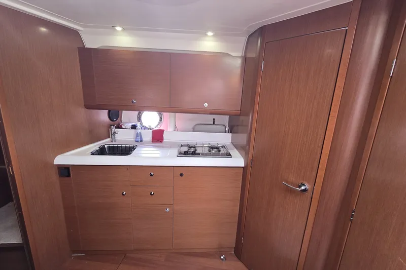 Slide: The Image of 2013 Beneteau Gran Turismo 38 yacht kitchen with wooden cabinets and modern appliances. - 22