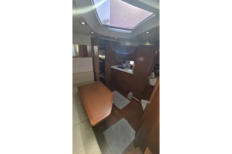 Slide: The Image of Interior of 2013 Beneteau Gran Turismo 38 yacht, featuring a cozy cabin and skylight. - 21