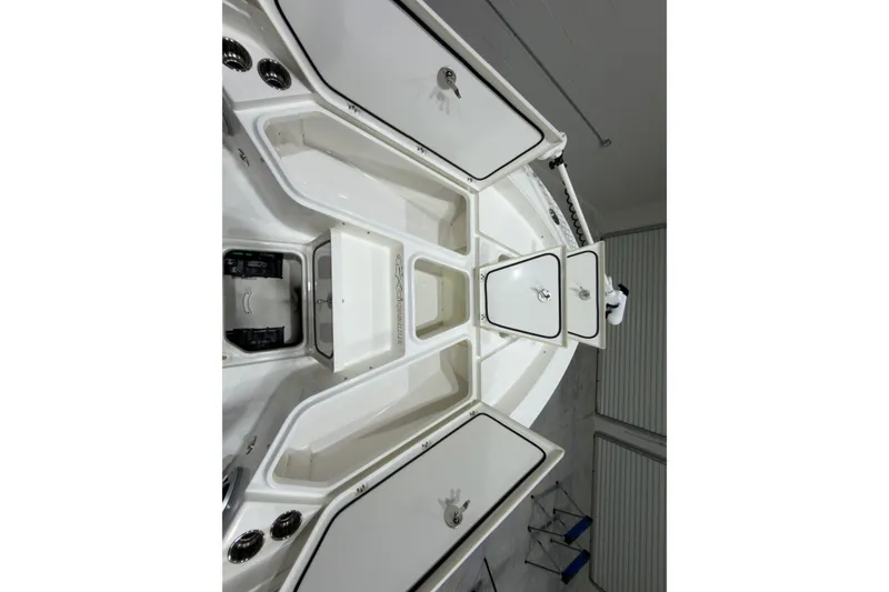 Slide: The Image of The image shows the deck of a 2019 Crevalle 26 Bay boat with open storage compartments. - 9