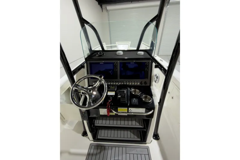 Slide: The Image of 2019 Crevalle 26 Bay boat dashboard with steering wheel and dual displays. - 2