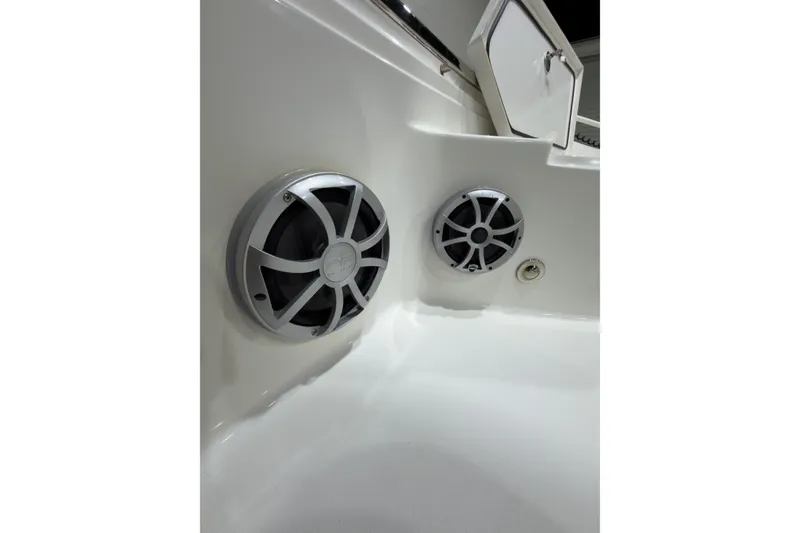 Slide: The Image of 2019 Crevalle 26 Bay boat interior with dual speakers and storage compartment. - 22
