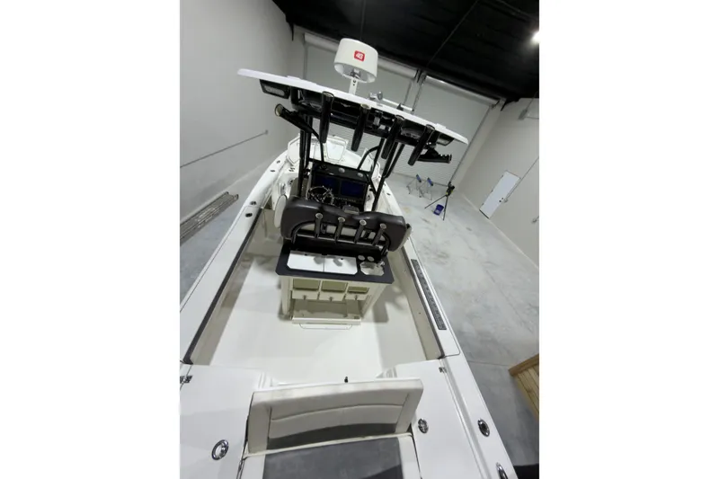 Slide: The Image of 2019 Crevalle 26 Bay boat interior with helm and seating in a garage. - 11