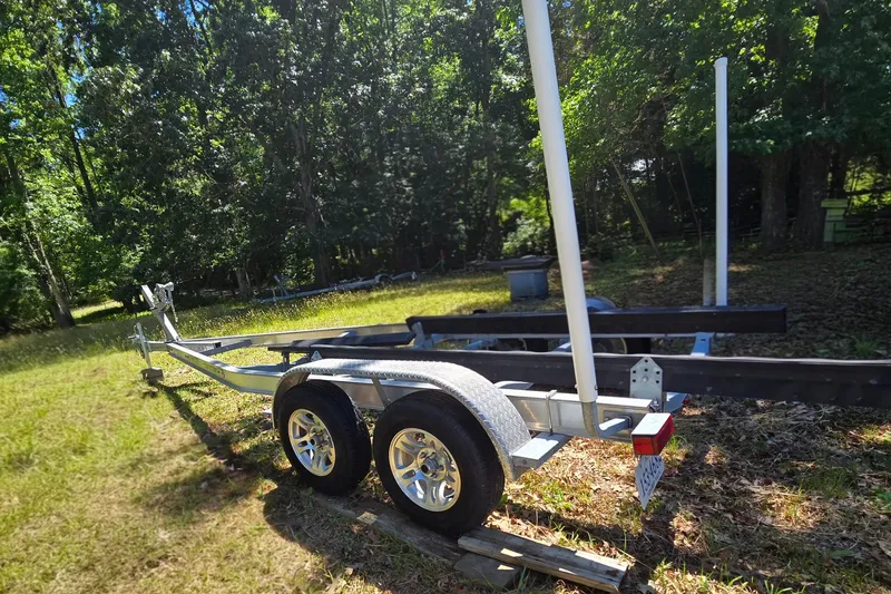 Slide: The Image of 2008 Triton 240 LTS Pro boat trailer in a sunny wooded area. - 11