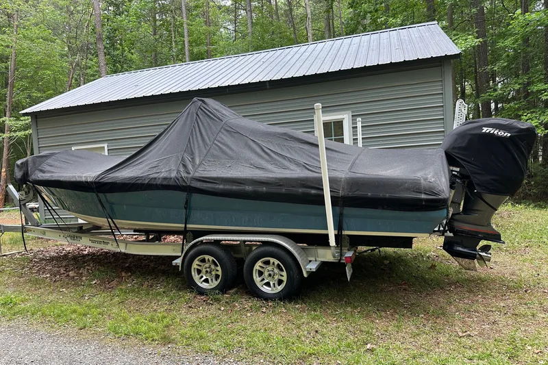 Slide: The Image of Covered 2008 Triton 240 LTS Pro boat on trailer, parked near a metal shed. - 12