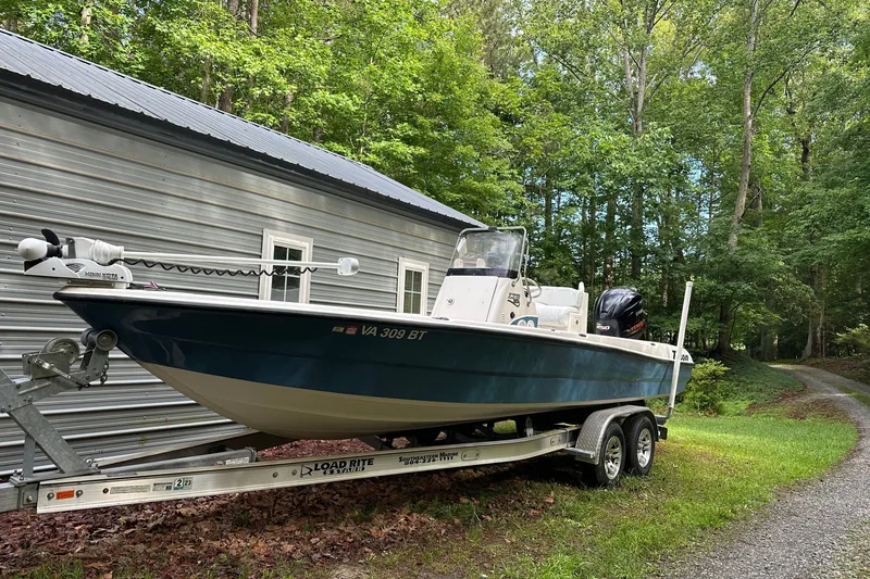 Slide: The Image of 2008 Triton 240 LTS Pro boat on trailer beside metal building, surrounded by trees. - 14
