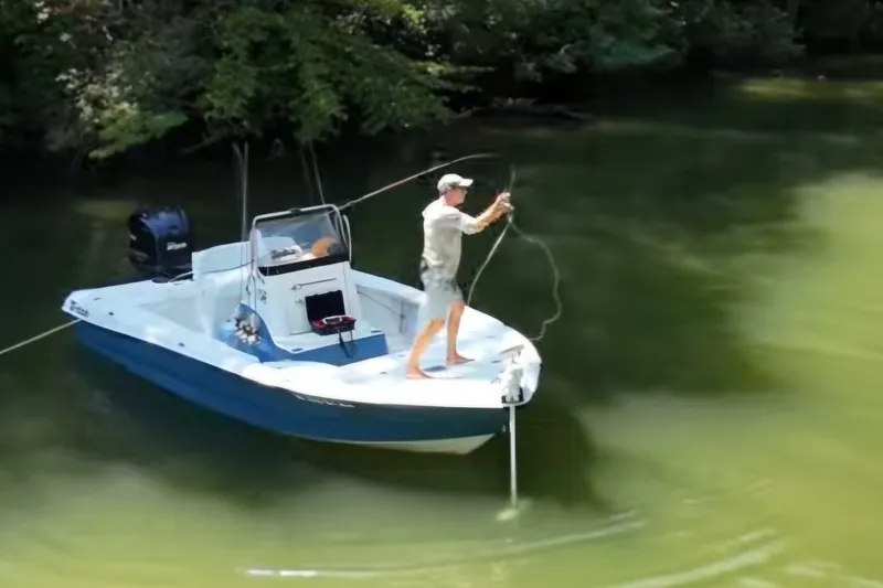 Slide: The Image of Man fishing on a 2008 Triton 240 LTS Pro boat in a calm river. - 4