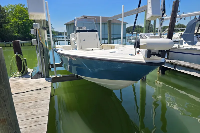 Slide: The Image of 2008 Triton 240 LTS Pro boat docked in a marina, surrounded by calm water. - 2
