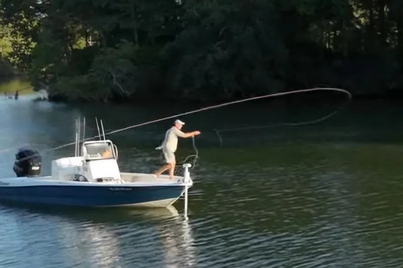 Slide: The Image of Man fly fishing on a 2008 Triton 240 LTS Pro boat in a serene lake. - 5