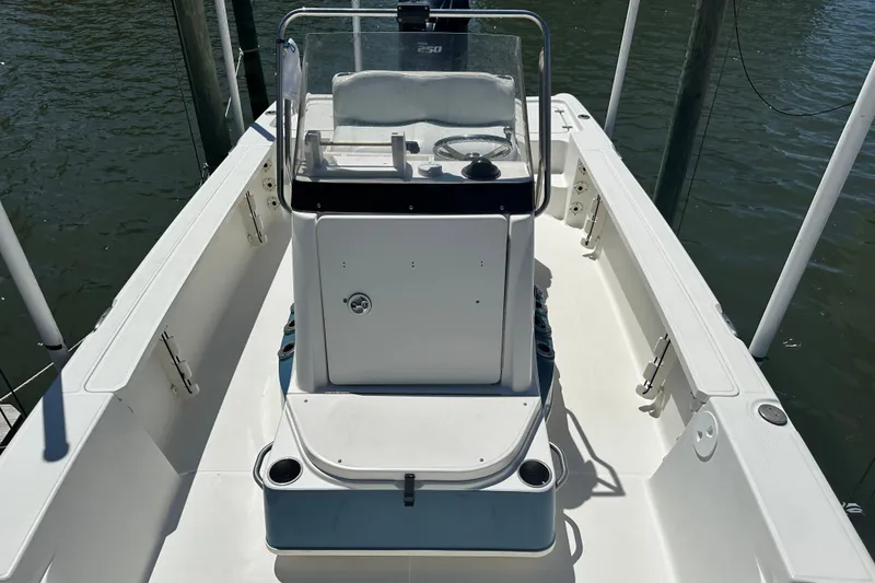 Slide: The Image of 2008 Triton 240 LTS Pro boat interior with steering console, docked on calm water. - 26