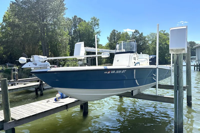 Slide: The Image of 2008 Triton 240 LTS Pro boat docked on a lift, surrounded by trees and water. - 7
