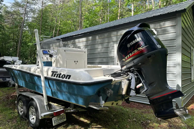 Slide: The Image of 2008 Triton 240 LTS Pro boat with Yamaha engine, parked near a metal building. - 15