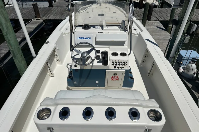 Slide: The Image of 2008 Triton 240 LTS Pro boat interior with steering console and seating at dock. - 16