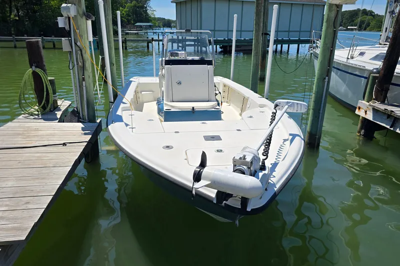 Slide: The Image of 2008 Triton 240 LTS Pro boat docked in calm waters, featuring a trolling motor. - 3