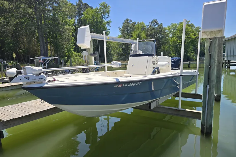 The Image of 2008 Triton 240 LTS Pro boat docked on a lift in a serene marina. - 1