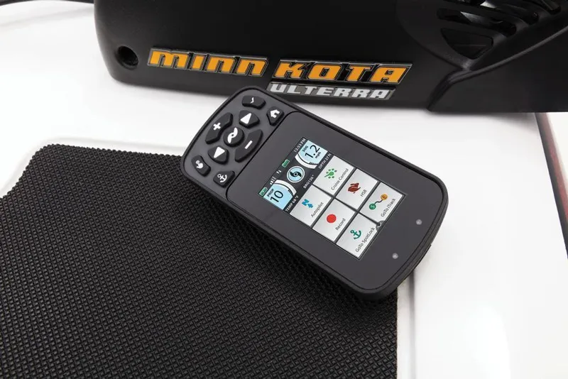 Slide: The Image of A control device with a screen and buttons rests on a textured surface next to a Minn Kota Ulterra. - 22