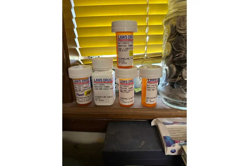 Slide: The Image of Prescription bottles and a jar of coins on a windowsill with yellow blinds. - 56
