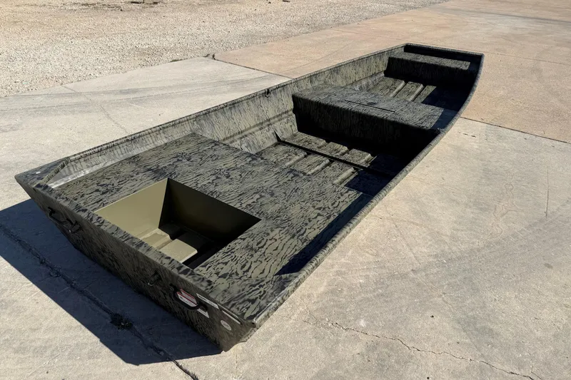 The Image of 2027 Tracker Grizzly 15 Jon boat on concrete surface, showcasing rugged design. - 0