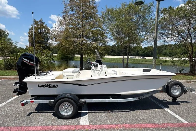 The Image of 2026 Mako Pro Skiff 15 CC boat on trailer, parked near a scenic lake. - 0