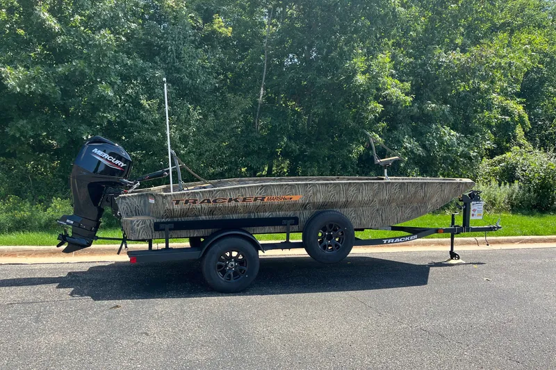 The Image of 2027 Tracker Grizzly 1756 T Marsh boat on trailer, parked on a sunny road. - 0