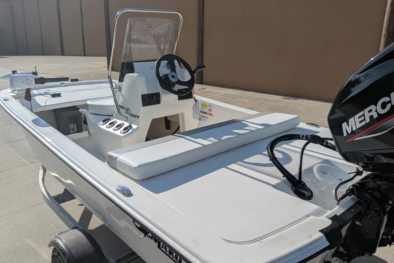 Slide: The Image of 2026 Mako Pro Skiff 13 CC boat with Mercury engine, parked on a trailer. - 3