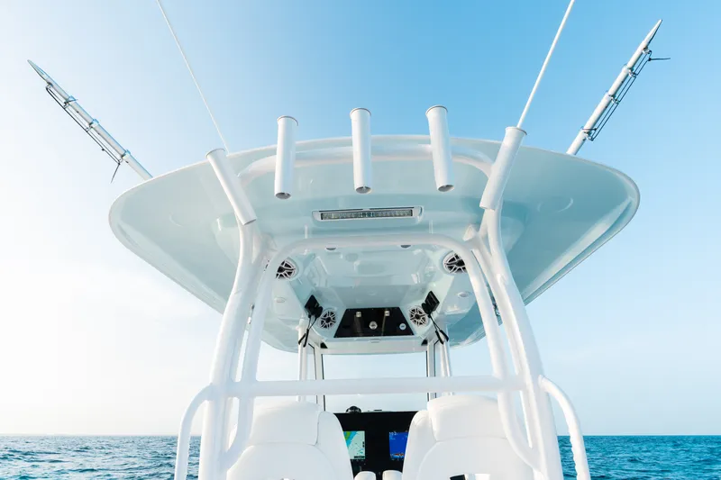 Slide: The Image of 2027 Sportsman Open 302 Center Console boat on open sea under clear blue sky. - 24