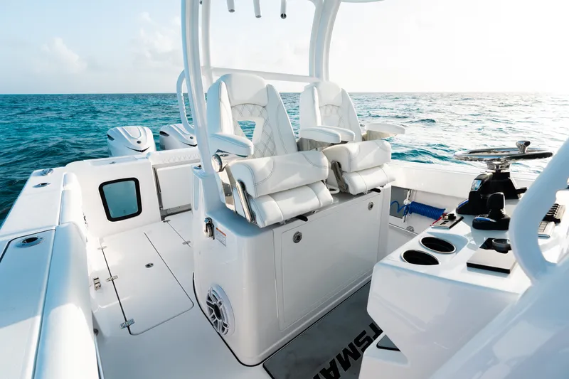 Slide: The Image of 2027 Sportsman Open 302 Center Console boat interior with white seating and ocean backdrop. - 13