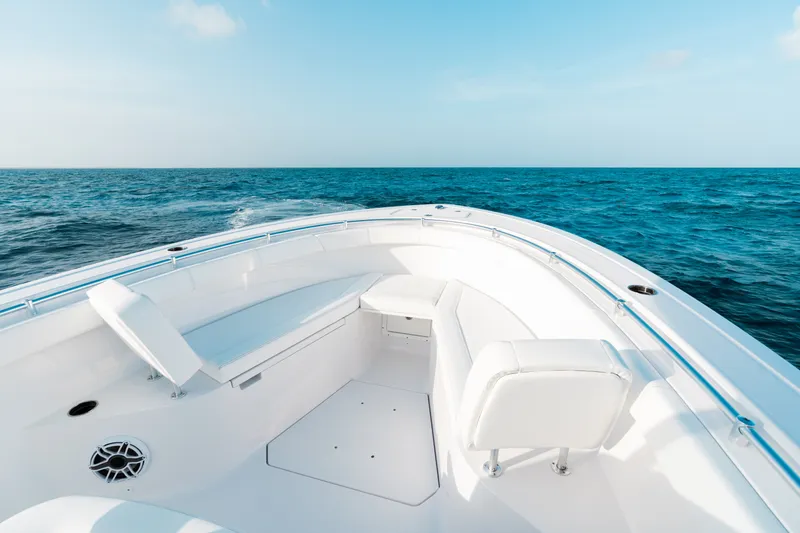 Slide: The Image of 2027 Sportsman Open 302 Center Console boat on open sea, featuring sleek white seating. - 2