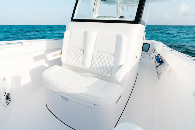 Slide: The Image of 2027 Sportsman Open 302 Center Console boat interior with white seating, ocean backdrop. - 8