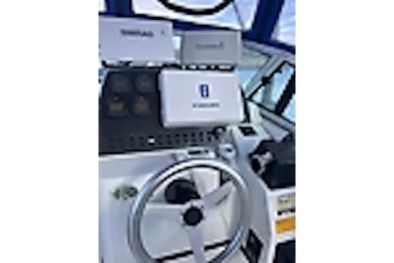 Slide: The Image of Helm of 2003 Triton 2690 WA boat with steering wheel and navigation equipment. - 3