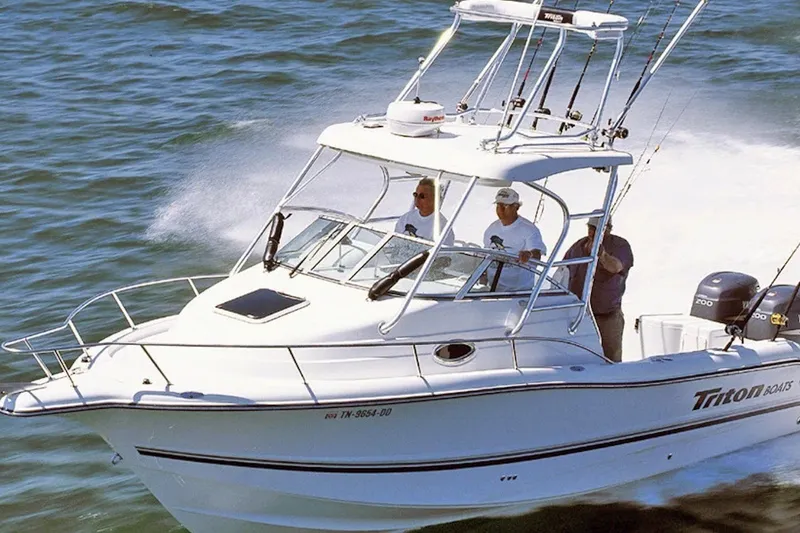 The Image of 2003 Triton 2690 WA boat cruising on open water with passengers onboard. - 0