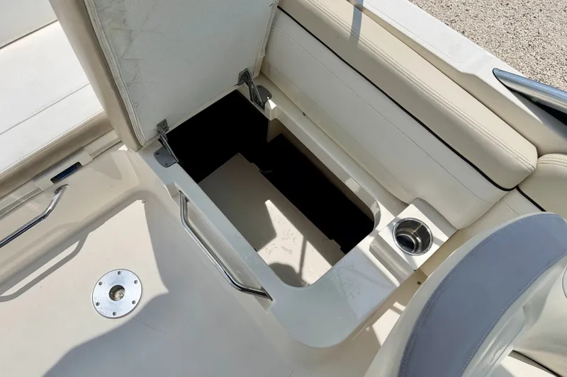 Slide: The Image of 2013 Sea Ray 260 Sundeck storage compartment with open seat and cup holder. - 38