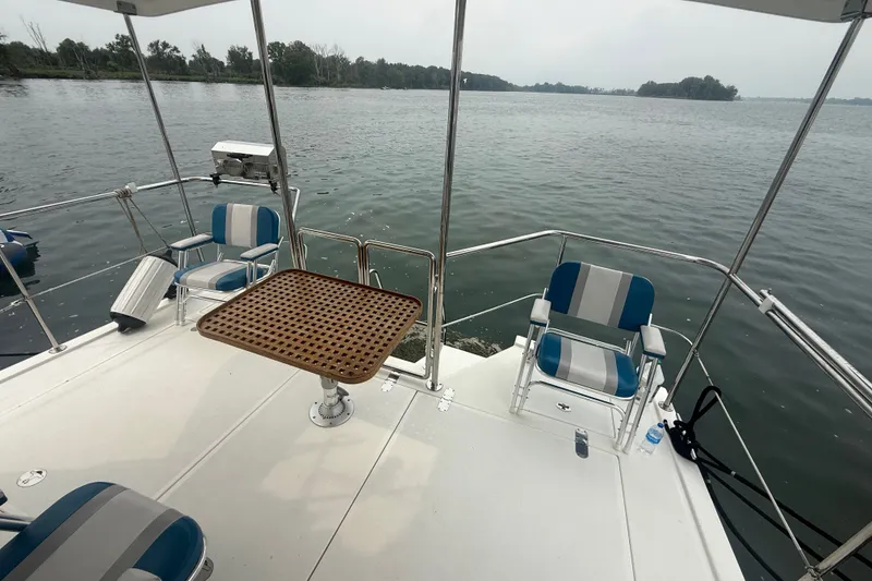 Slide: The Image of 2006 Island Pilot 395 boat deck with chairs and table overlooking calm water. - 8