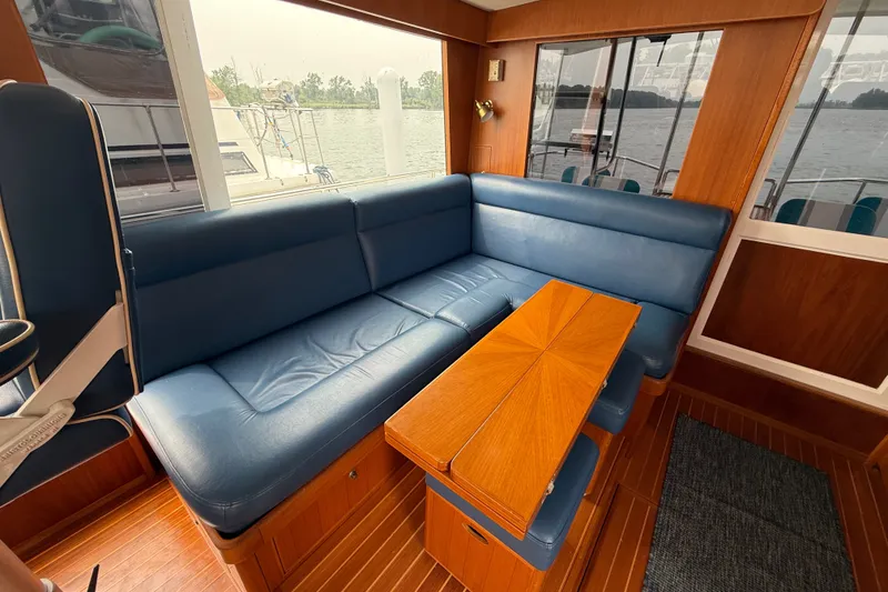 Slide: The Image of Luxurious 2006 Island Pilot 395 yacht interior with blue leather seating and wooden table. - 17