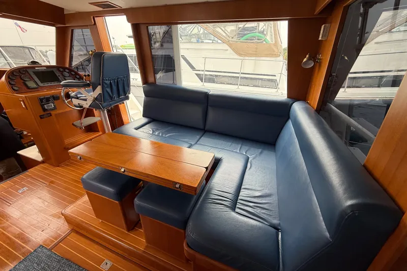 Slide: The Image of Interior of 2006 Island Pilot 395 yacht with blue seating and wooden accents. - 16