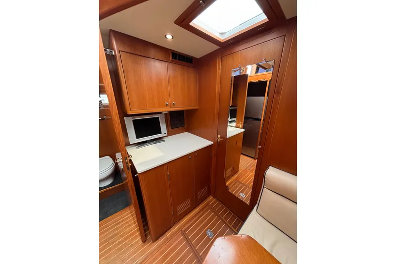 Slide: The Image of 2006 Island Pilot 395 yacht interior with wood cabinetry, skylight, and compact workspace. - 36
