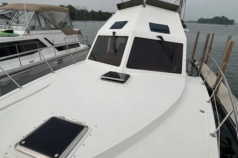 Slide: The Image of 2006 Island Pilot 395 yacht docked, showcasing sleek white deck and windows. - 4