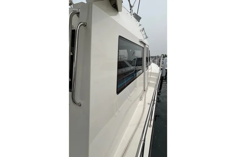 Slide: The Image of Side view of a 2006 Island Pilot 395 yacht docked at a marina. - 7