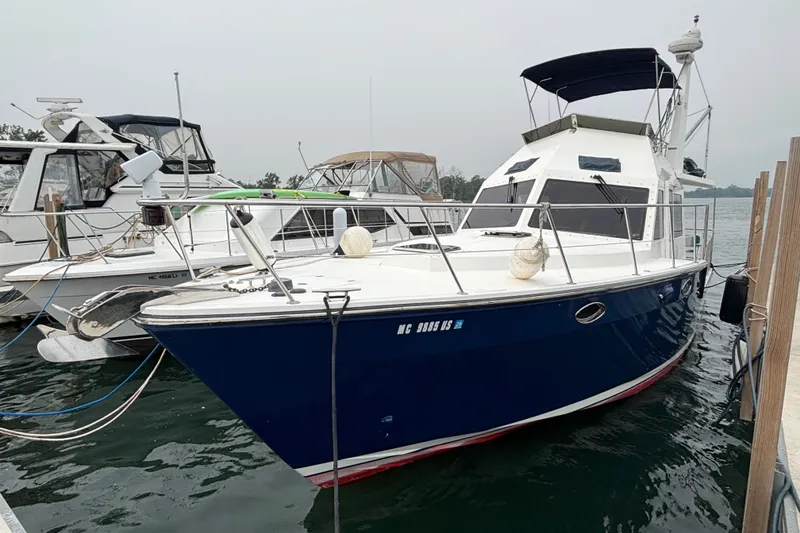 Slide: The Image of 2006 Island Pilot 395 boat docked in marina, featuring sleek blue hull and spacious deck. - 1