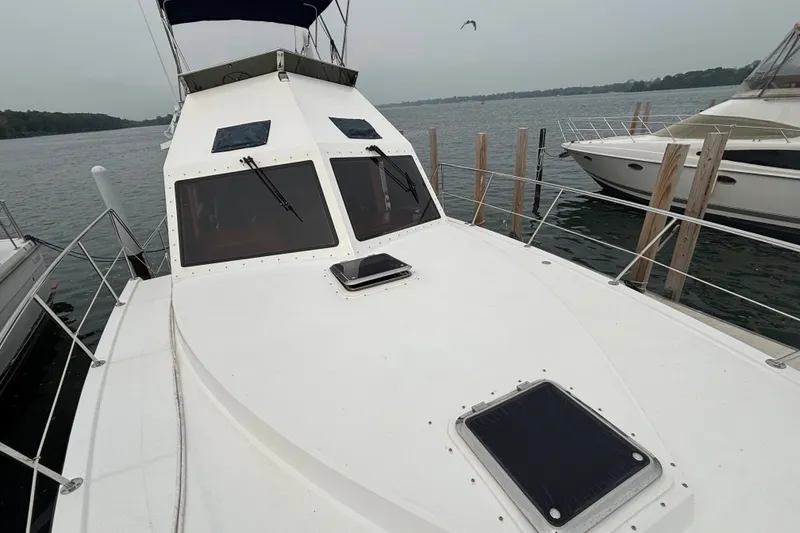 Slide: The Image of 2006 Island Pilot 395 yacht docked, showcasing sleek design and spacious deck. - 2