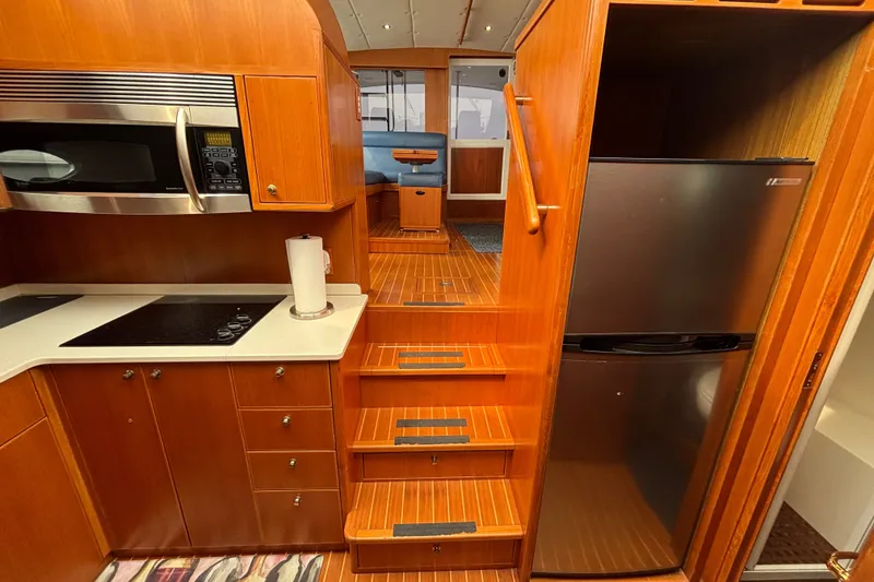 Slide: The Image of 2006 Island Pilot 395 interior with kitchen, microwave, fridge, and wooden stairs. - 32