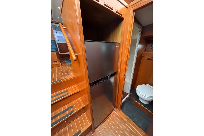 Slide: The Image of 2006 Island Pilot 395 interior with wooden stairs, fridge, and bathroom. - 33